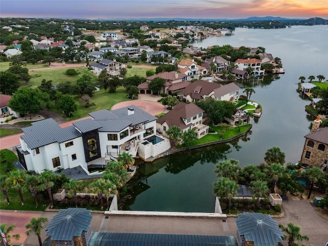 aerial view at dusk featuring a water view