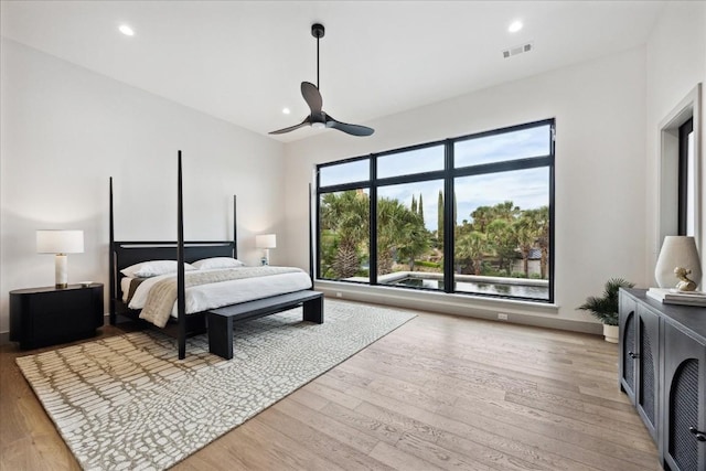 bedroom with multiple windows, ceiling fan, and light hardwood / wood-style flooring