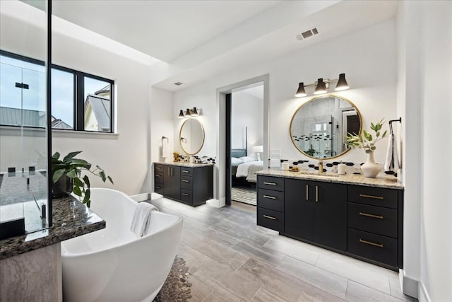 bathroom with a tub to relax in and vanity