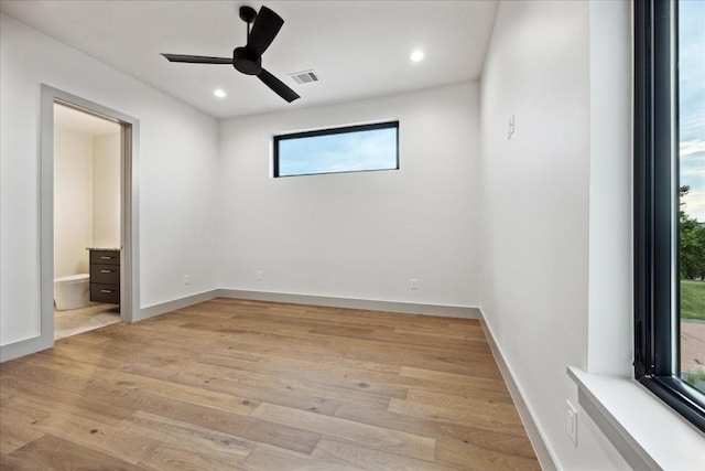 empty room with ceiling fan and light hardwood / wood-style floors