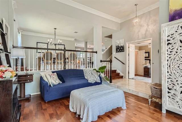 living room with hardwood / wood-style flooring, a notable chandelier, and crown molding