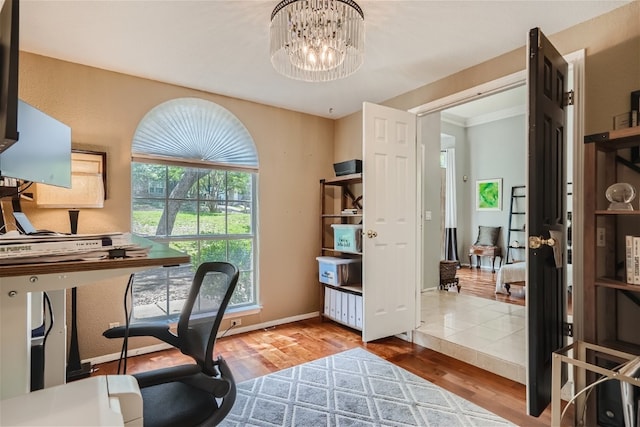 office area with baseboards, an inviting chandelier, and wood finished floors