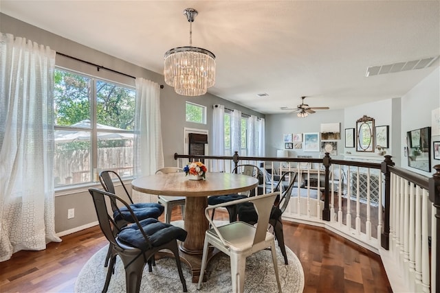 dining area with plenty of natural light, wood-type flooring, and ceiling fan with notable chandelier