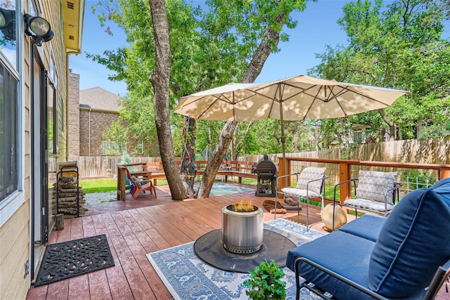 wooden deck with grilling area and a fenced backyard