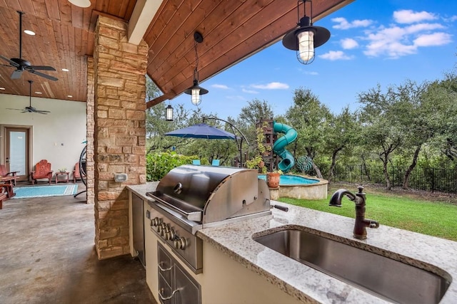 view of patio featuring a grill, ceiling fan, sink, and an outdoor kitchen