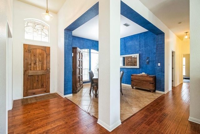 foyer entrance featuring light hardwood / wood-style flooring and a high ceiling