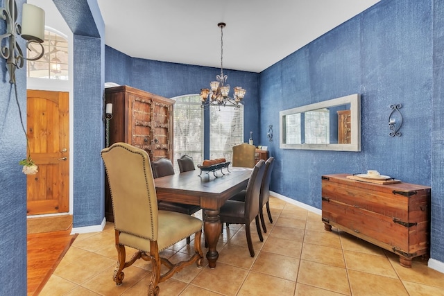 dining area featuring light tile patterned flooring and a chandelier