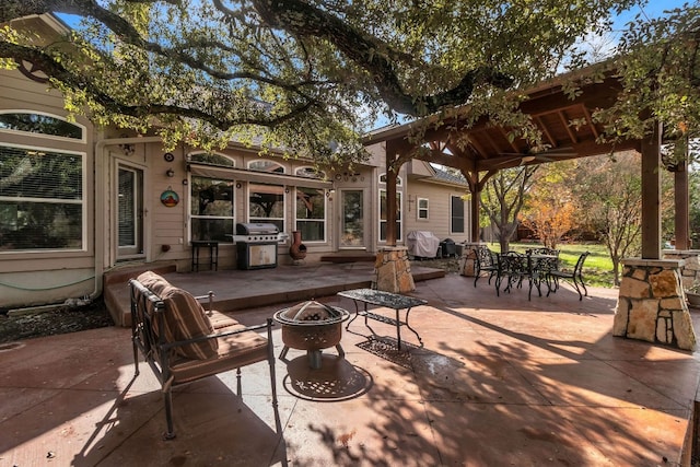 view of patio with area for grilling and a fire pit