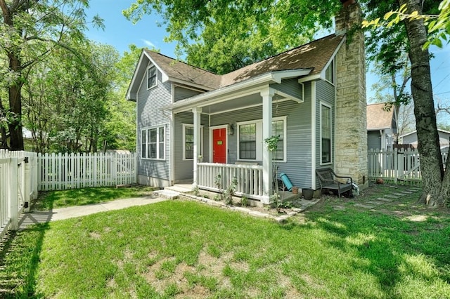 back of property with a yard and covered porch