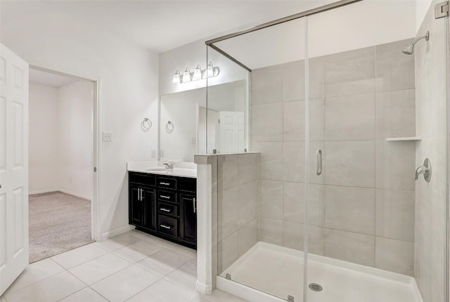 full bath with a stall shower, tile patterned flooring, baseboards, and vanity