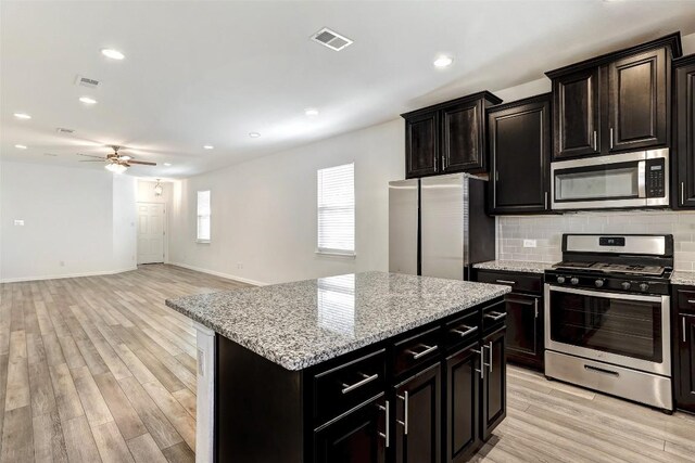 kitchen featuring appliances with stainless steel finishes, light wood-style floors, visible vents, and tasteful backsplash