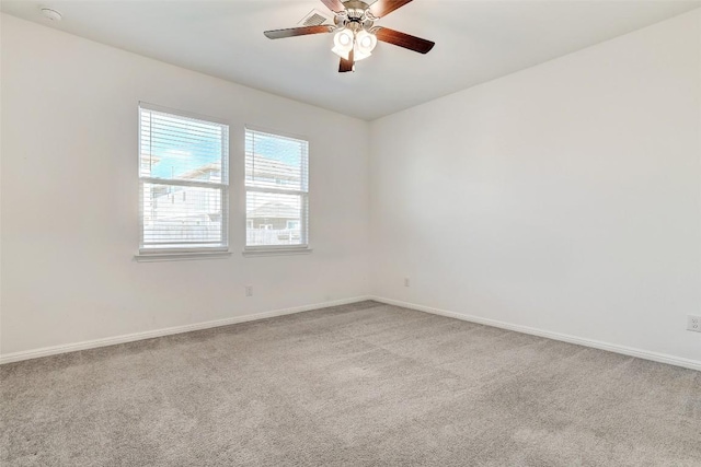 carpeted empty room with baseboards and a ceiling fan