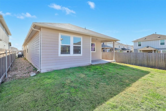 rear view of property with a patio area, a fenced backyard, and a lawn