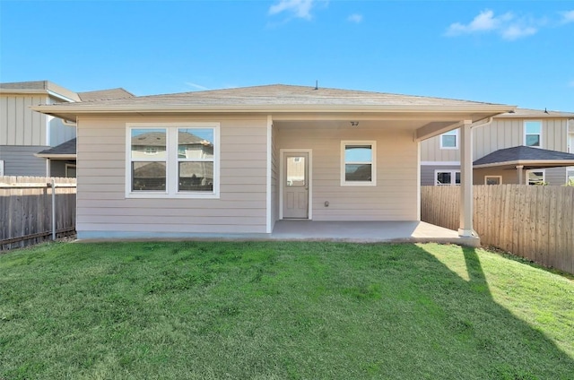 back of house with a fenced backyard, a lawn, and a patio