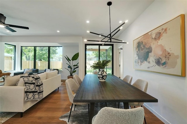 dining area featuring ceiling fan with notable chandelier and dark hardwood / wood-style floors