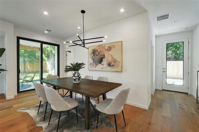 dining space featuring a wealth of natural light, light hardwood / wood-style flooring, and a notable chandelier