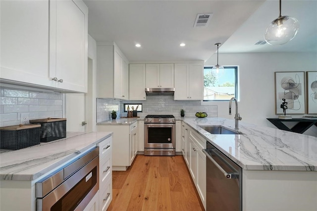 kitchen with white cabinetry, sink, stainless steel appliances, and decorative light fixtures