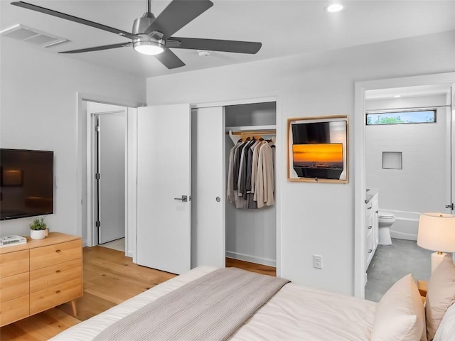 bedroom with ensuite bathroom, light hardwood / wood-style flooring, and ceiling fan