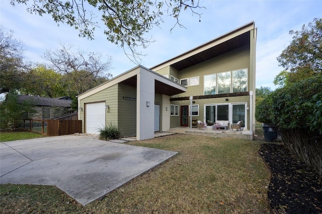 back of property with a garage and a lawn