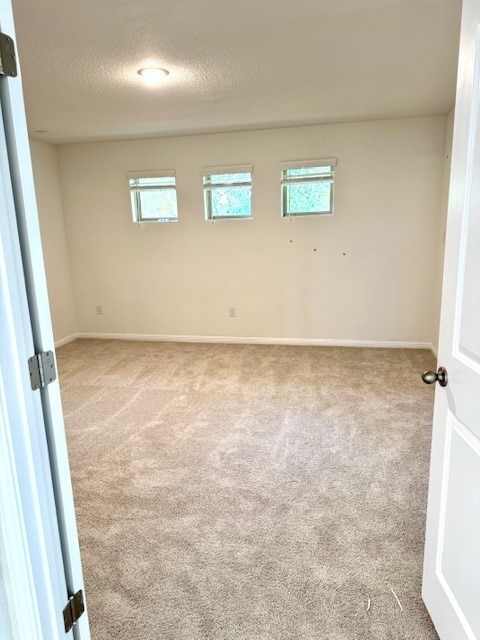 carpeted spare room with a textured ceiling