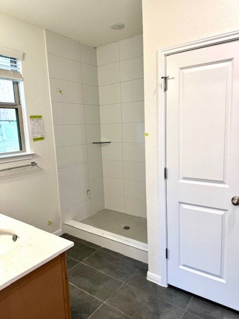 bathroom featuring tile patterned floors, vanity, and tiled shower