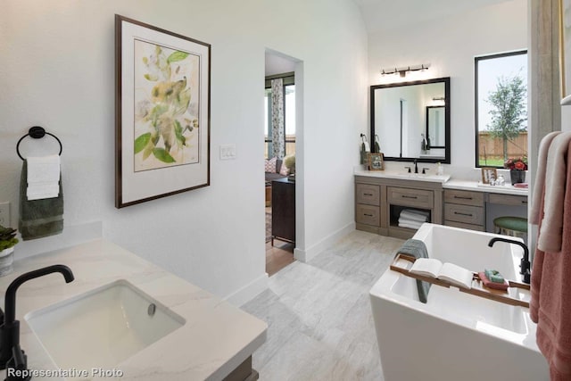 bathroom with a tub to relax in and vanity