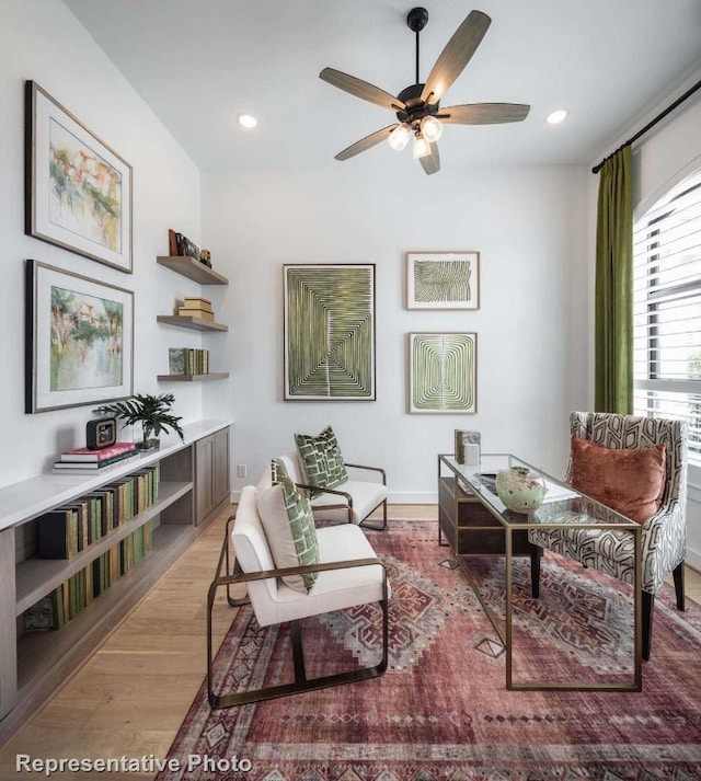 sitting room with hardwood / wood-style flooring and ceiling fan