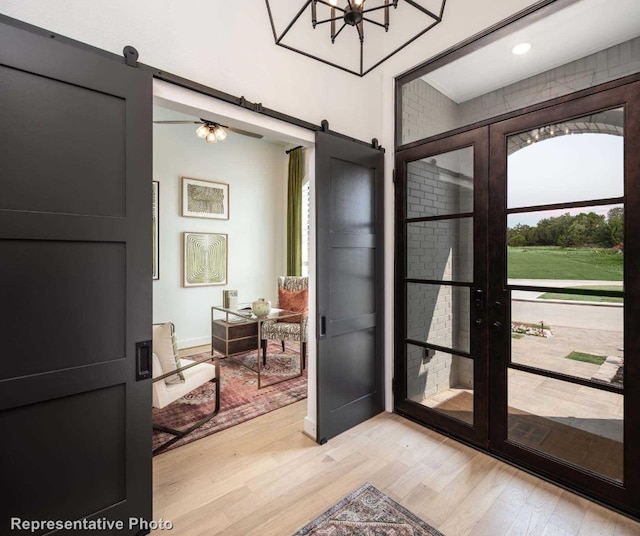 entrance foyer with a barn door and light hardwood / wood-style flooring