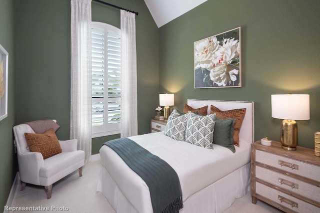 bedroom with lofted ceiling and light carpet