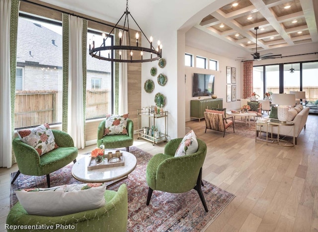 interior space featuring ceiling fan with notable chandelier, beamed ceiling, and coffered ceiling