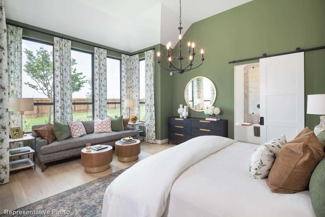 bedroom with hardwood / wood-style flooring, a notable chandelier, a barn door, and lofted ceiling