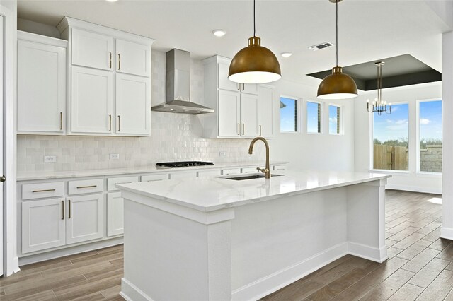 149 Golden Sage Ave, Georgetown, TX 78633 - kitchen featuring wall chimney exhaust hood, wood finished floors, gas stovetop, tasteful backsplash, and recessed lighting