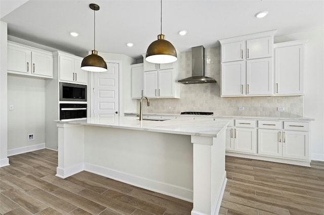 149 Golden Sage Ave, Georgetown, TX 78633 - kitchen featuring wall chimney range hood, black appliances, light wood finished floors, white cabinets, and recessed lighting