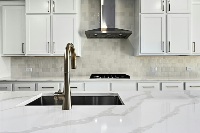 149 Golden Sage Ave, Georgetown, TX 78633 - kitchen featuring wall chimney exhaust hood, black cooktop, white cabinetry, and tasteful backsplash
