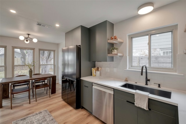 kitchen featuring decorative backsplash, light wood-type flooring, gray cabinetry, sink, and dishwasher