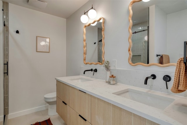 bathroom featuring tile patterned floors, vanity, toilet, and a shower with shower door