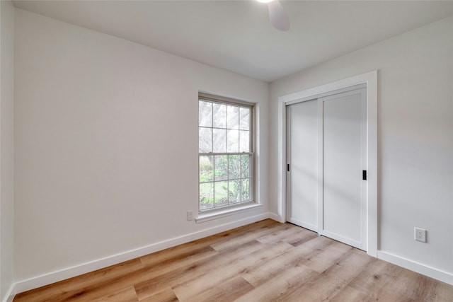 unfurnished bedroom with a closet, light hardwood / wood-style floors, and ceiling fan