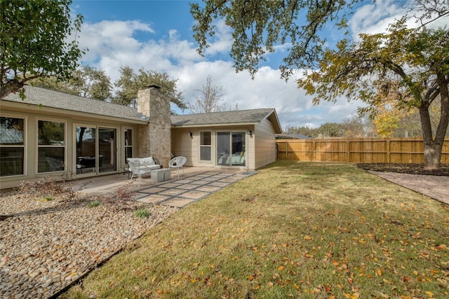 rear view of property featuring a lawn and a patio