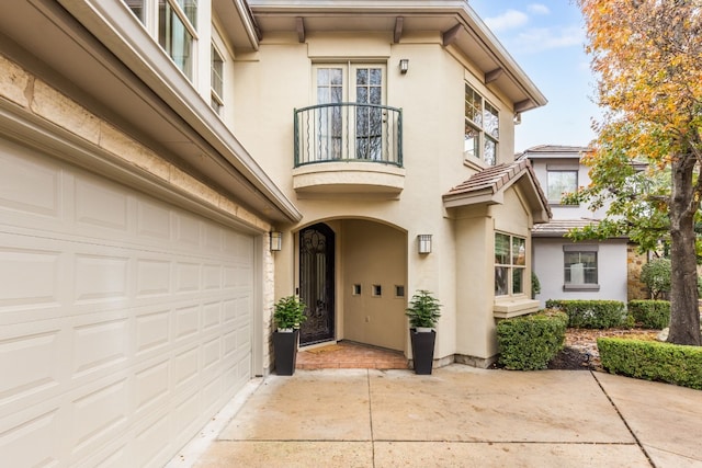 doorway to property featuring a garage and a balcony