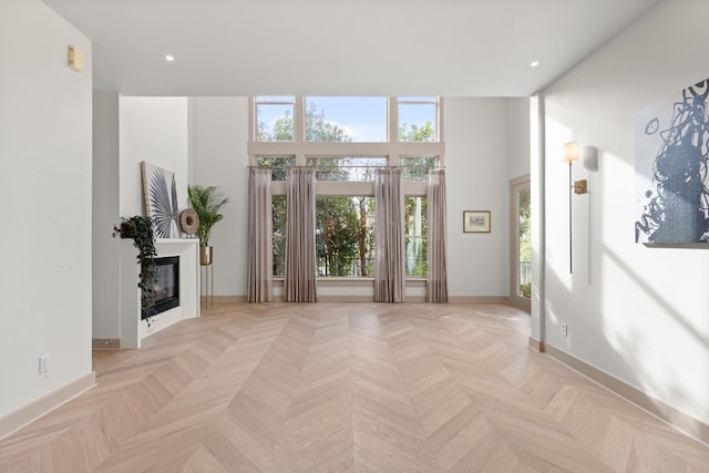 unfurnished living room featuring a wealth of natural light and light parquet floors