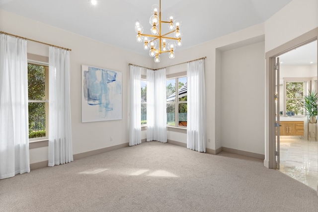 empty room featuring light carpet and a notable chandelier