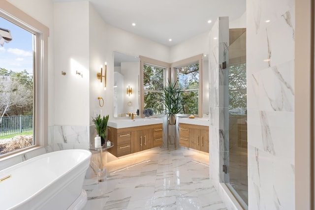 bathroom featuring shower with separate bathtub, vanity, a wealth of natural light, and tile walls