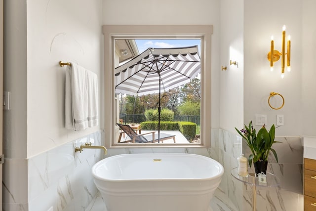 bathroom with a bathtub, tile walls, and a wealth of natural light