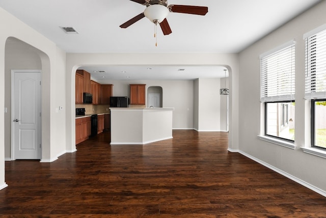 unfurnished living room featuring dark hardwood / wood-style floors, a wealth of natural light, and ceiling fan