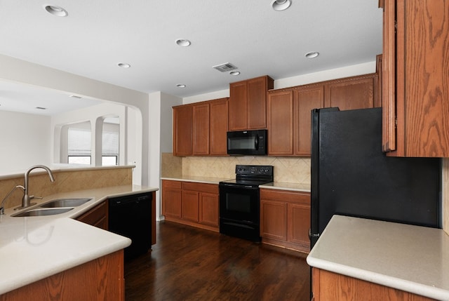 kitchen featuring sink, decorative backsplash, dark hardwood / wood-style flooring, and black appliances