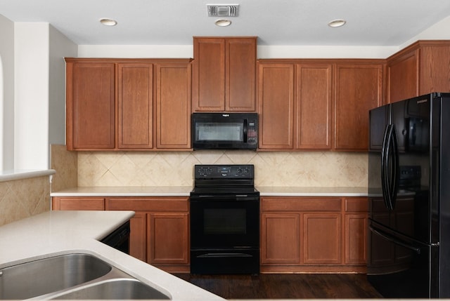 kitchen featuring black appliances, dark wood-type flooring, and tasteful backsplash