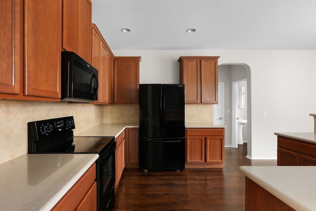 kitchen with backsplash, dark hardwood / wood-style flooring, and black appliances