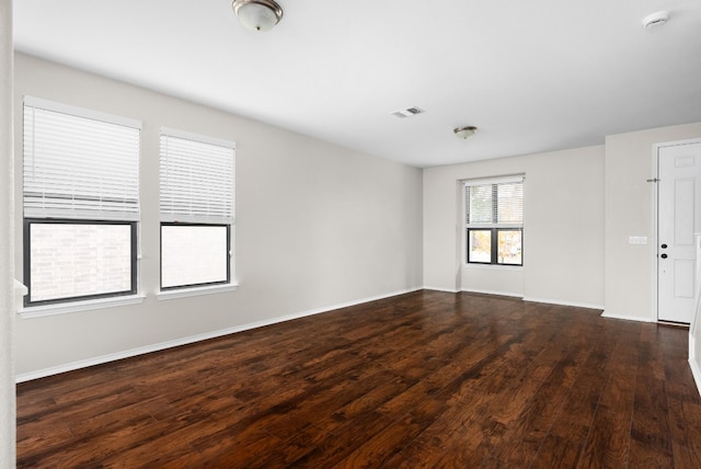 empty room with dark hardwood / wood-style flooring