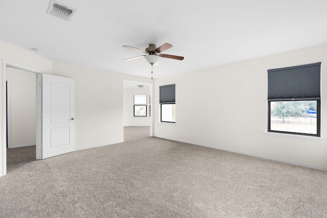 carpeted spare room featuring ceiling fan