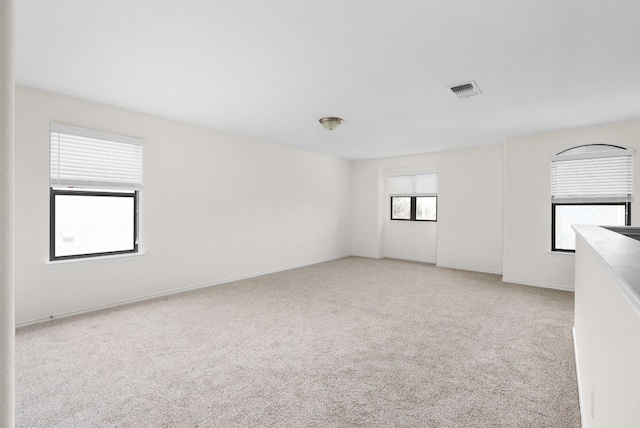 unfurnished room featuring light carpet